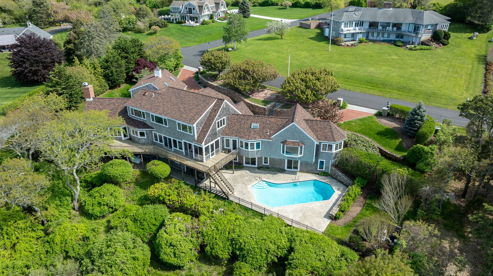 Aerial view of a shingle-style home with pool